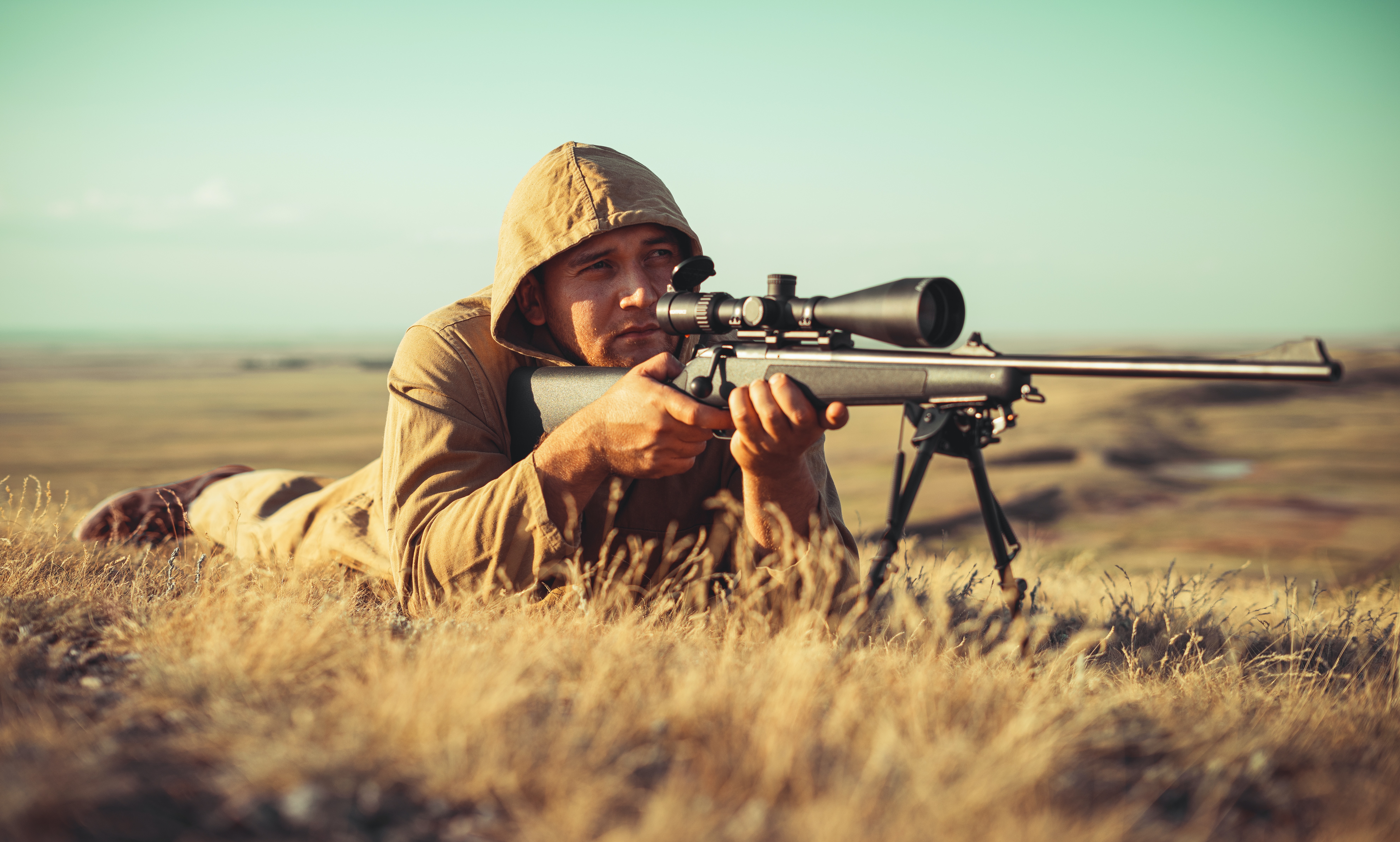 An image of a hunter with a rifle and binoculars, preparing for hunting in Mongolia